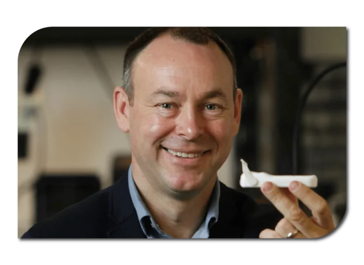 Smiling man holding white medical diagnostic platform